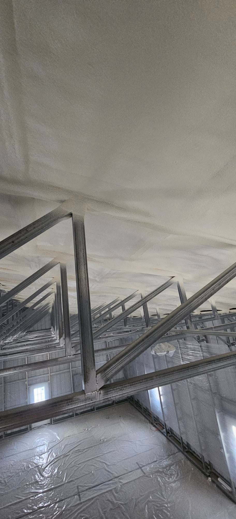 Close-up of closed-cell spray foam over metal roof framing