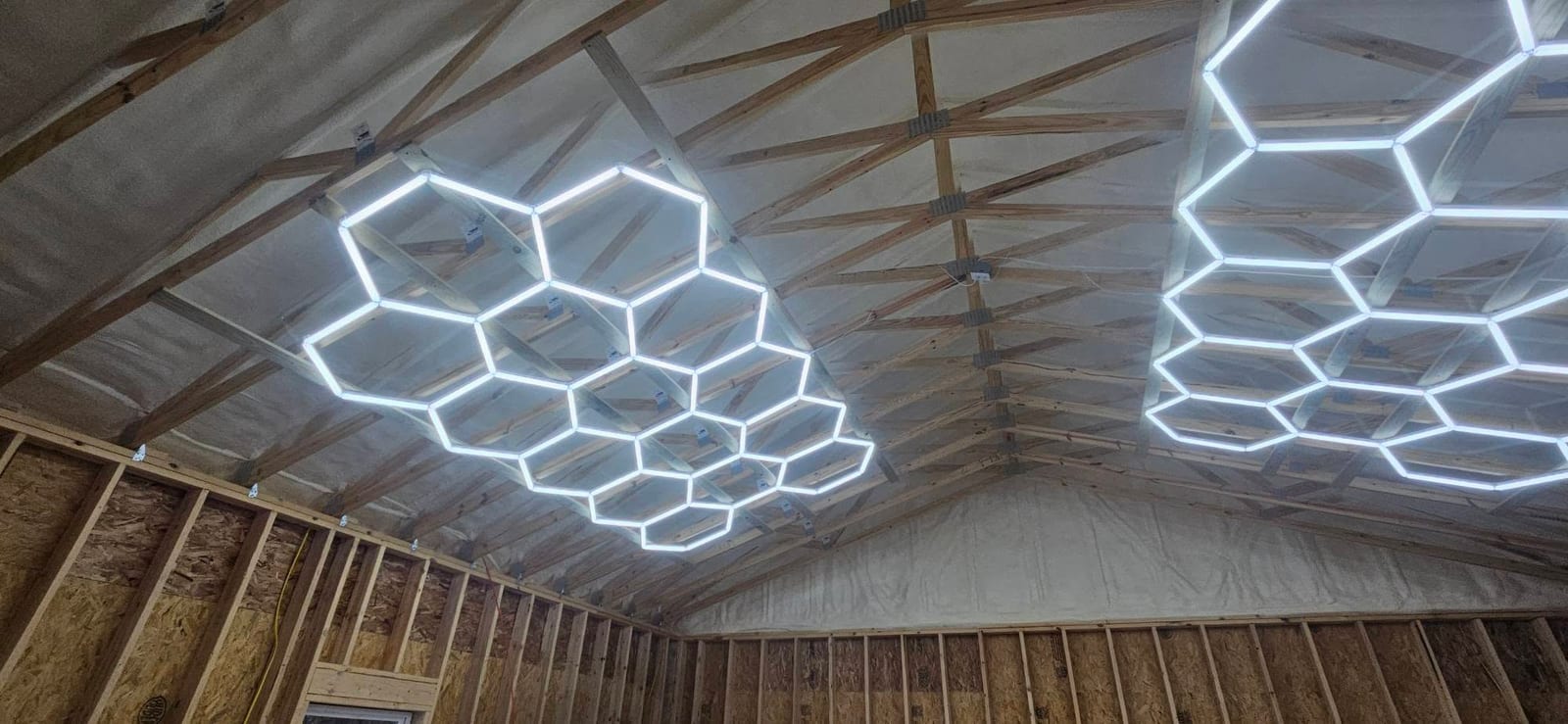 Garage ceiling insulated with spray foam under hex shop lights