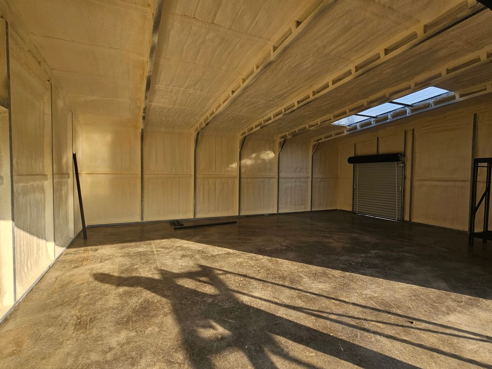 Large pole barn interior with spray foam insulation on the walls and roof deck