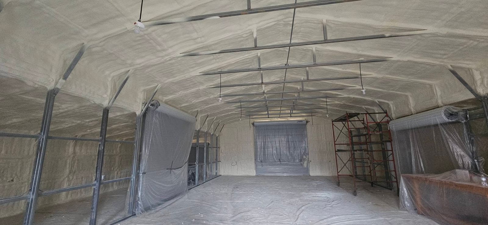 Metal building with spray foam on the arched ceiling and walls