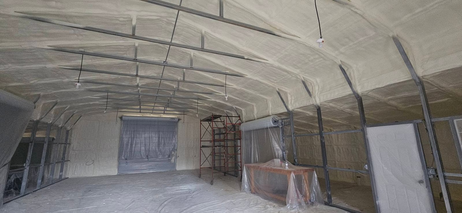Wide view of a metal building interior insulated with spray foam